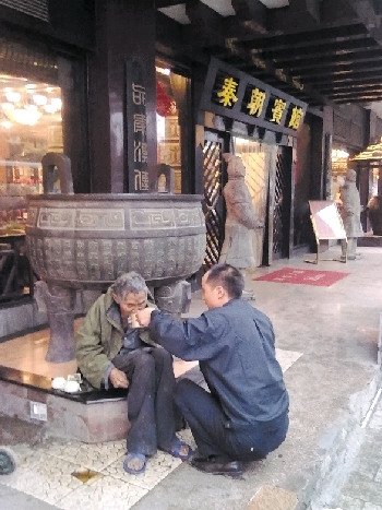 8月25日，网友申超在街头拍下的张副山喂老人吃面一幕。 