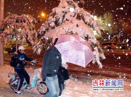 行人在雪中艰难行进。（来源：吉林新闻网张猛摄） 