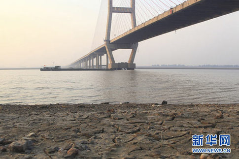 这是12月10日在江西省湖口县境内的鄱阳湖大桥附近拍摄的已经干涸开裂的湖滩。