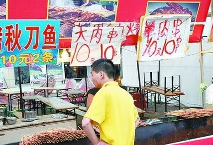 被查后，美食街上的'羊肉串'的'羊'字被涂抹了。