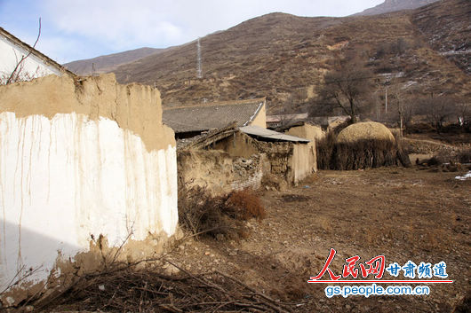 甘肃漳县大草滩乡新联村，“遮羞墙”内农户破败的房屋和院墙与新墙形成鲜明对比（人民网记者 高翔 张鹏 隋欣 摄）