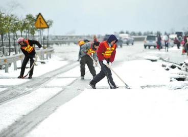 工作人员清理高速路上的积雪。 张磊摄