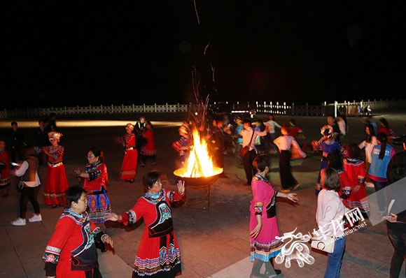 夜晚，当地的土家族妹子们围着篝火挑起了她们民族的摆手舞。简单的小跨步、弯腰、左右抬手臂，全国各地的记者朋友也纷纷加入摆手舞的行列，与土家族妹子一起舞蹈。 记者 刘嵩 摄.jpg